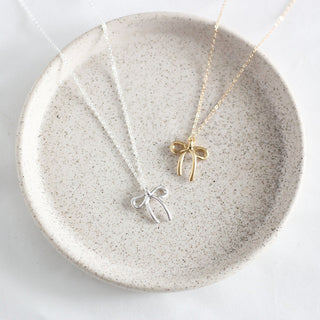A silver or gold bow necklace