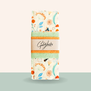 Packaged beeswax food wraps with a floral pattern, including three different sizes